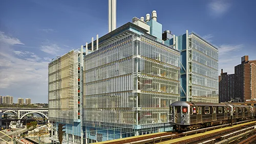 The 1 subway train crossing in front of the Jerome L. Greene Science Center building.